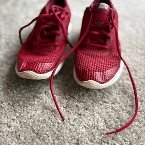 Nike Revolution 4 running shoes in red and white.
